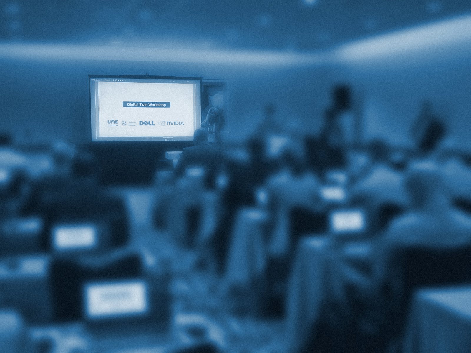 Uniformed and civilian attendees at laptops during the Digital Twin Workshop at I/ITSEC 2024