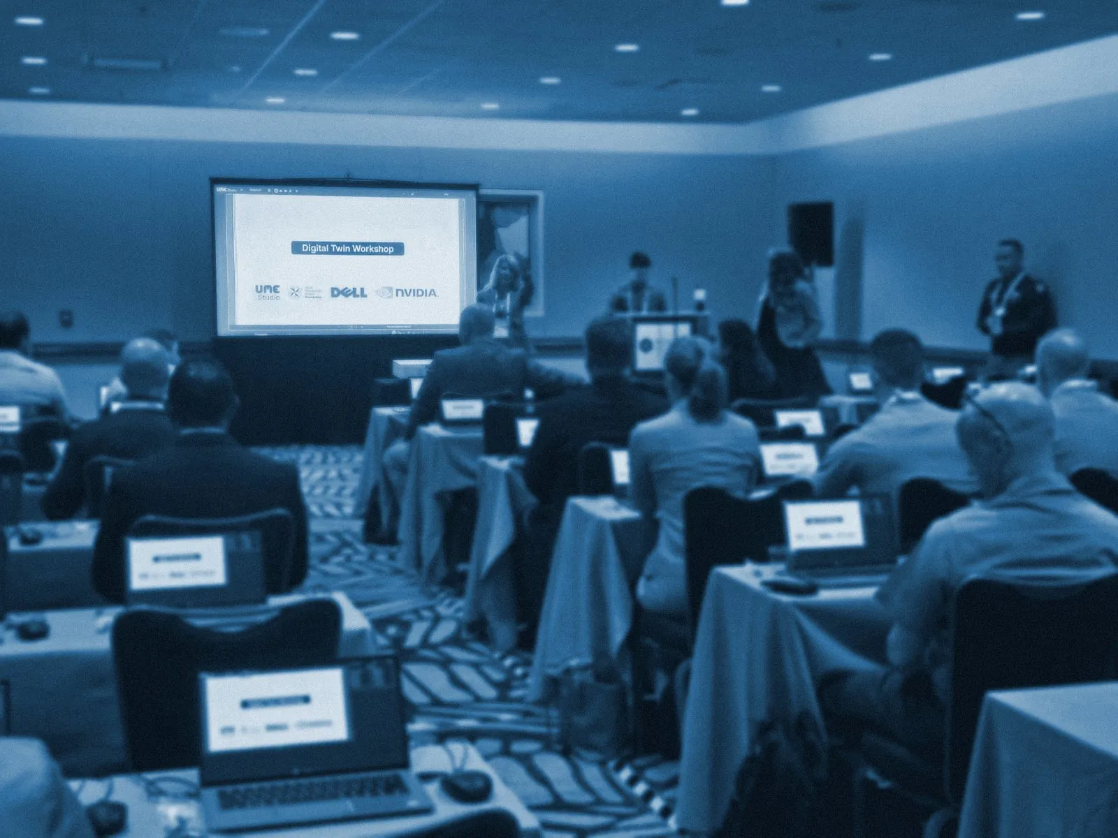 Uniformed and civilian attendees at laptops during the HADR simulation workshop at I/ITSEC 2024